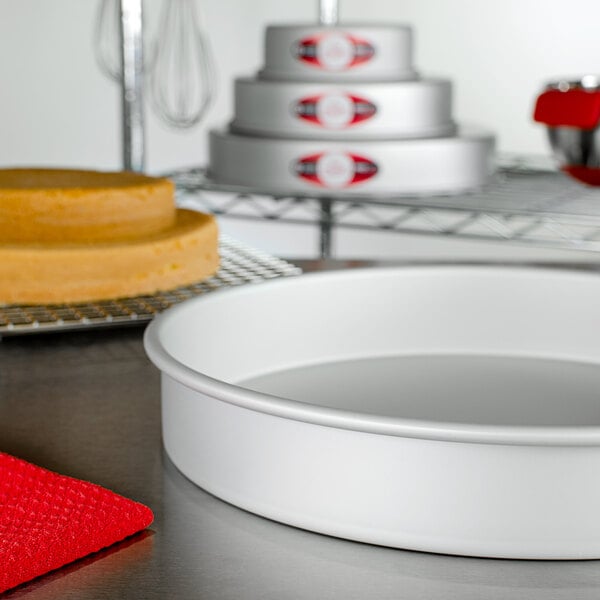 A Fat Daddio's round cake pan on a table with a cake in it.