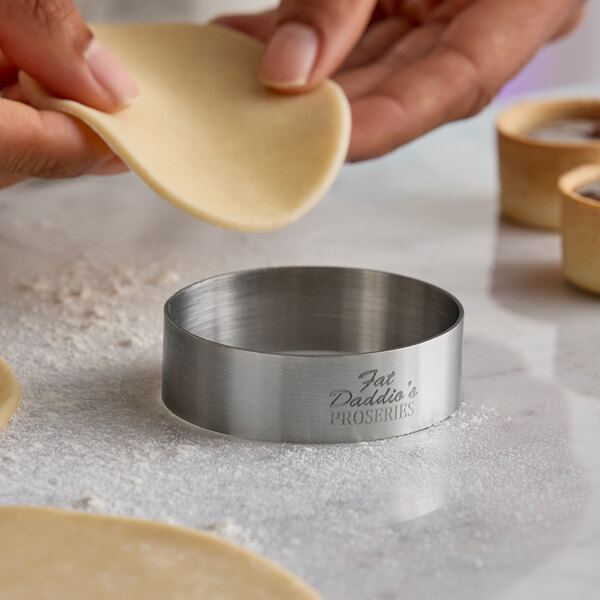 A stainless steel round tartlet ring or food ring mold with 'Fat Daddio's ProSeries' engraved on the side.