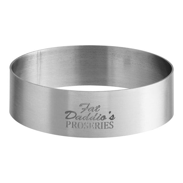 A close-up of a stainless steel Fat Daddio's round tartlet ring.