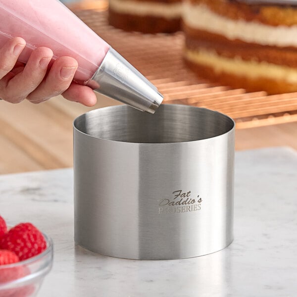 A stainless steel round cake and food ring mold measuring 4 inches by 3 inches.
