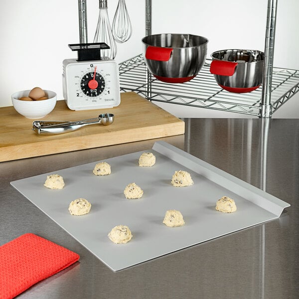A Fat Daddio's rimless anodized aluminum cookie sheet with cookies on it.