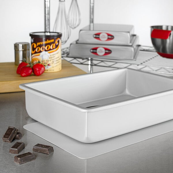 A white rectangular baking pan with a silver cylinder inside.
