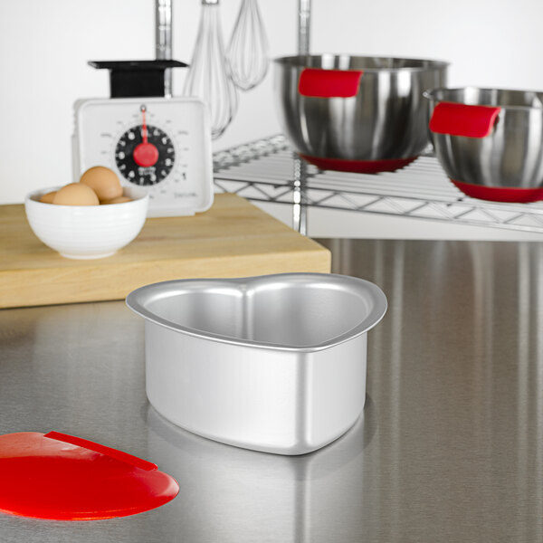 A Fat Daddio's heart shaped metal cake pan on a kitchen counter.