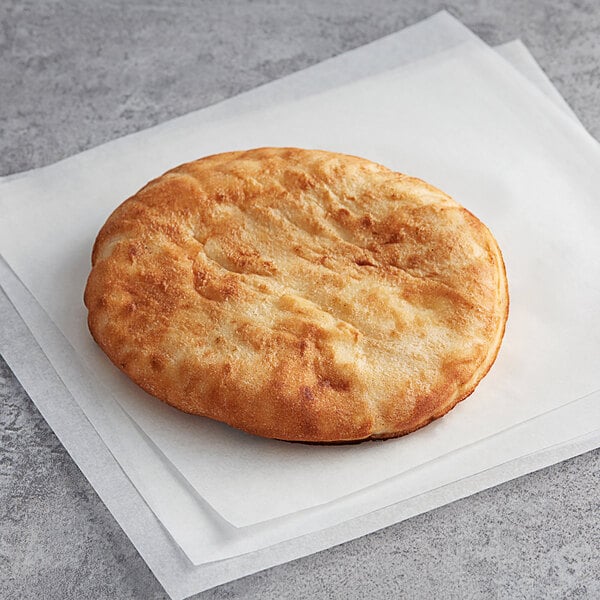 a round brown bread on a white napkin