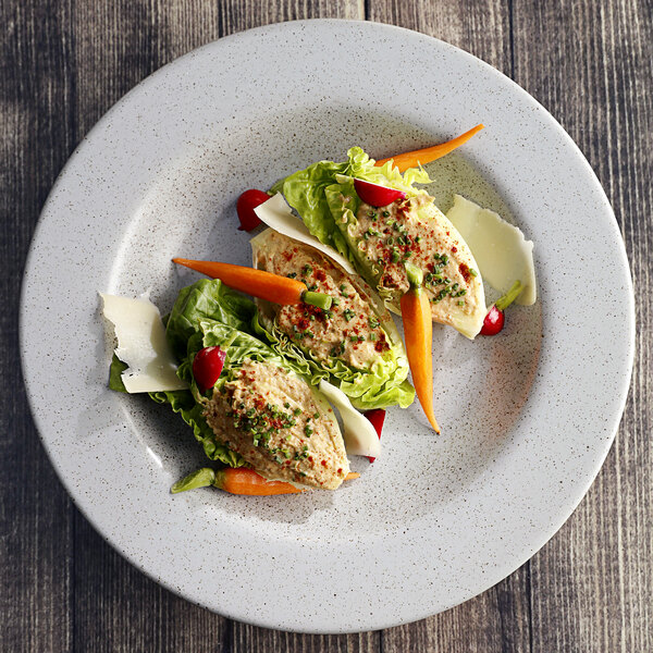 A Moon wide rim bowl filled with soup and pasta on a table with a plate of food.
