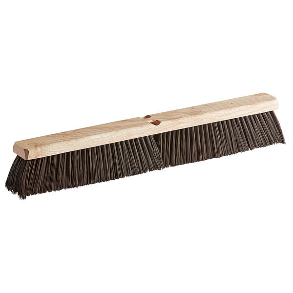 A close-up of a Carlisle hardwood push broom head with black bristles.