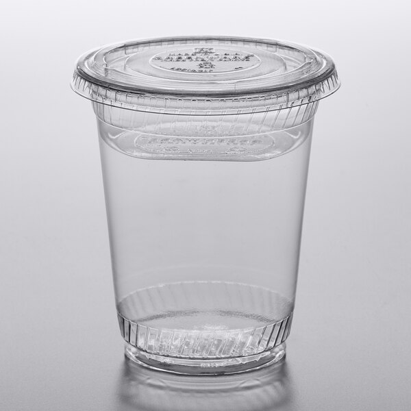A Fabri-Kal clear plastic parfait cup with a lid on a table.