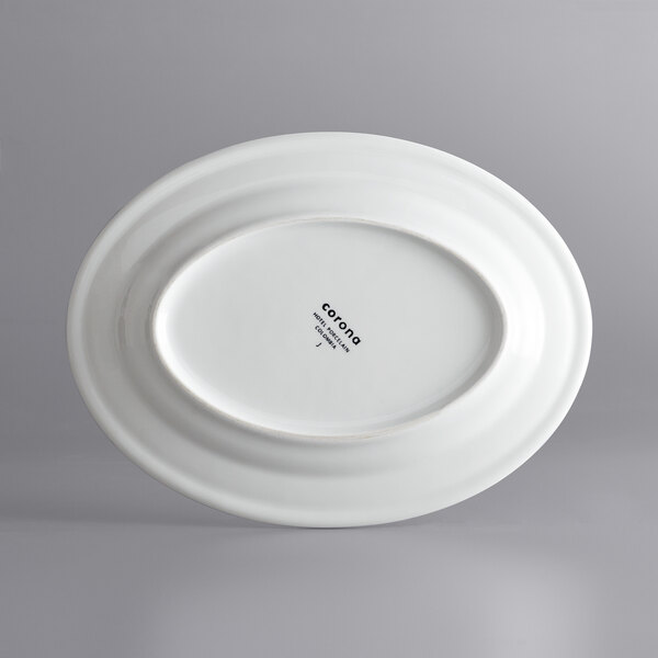 A white oval porcelain platter with a black logo.