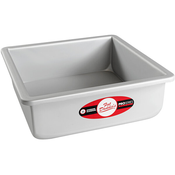 A silver square pan with a red and white label.