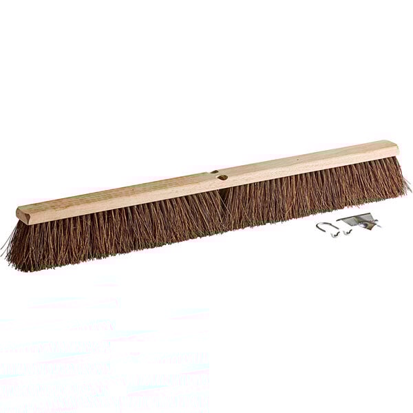 A Carlisle hardwood push broom head with Palmyra bristles and metal hooks.
