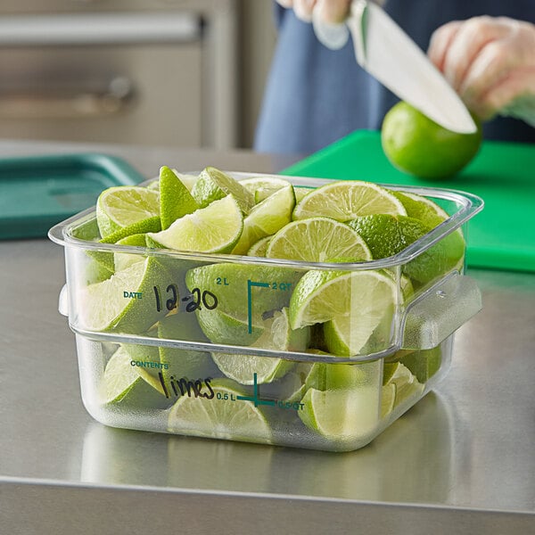 A person cutting limes in a Vigor food storage container.