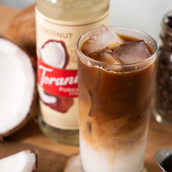 A glass of iced coffee with Torani Coconut syrup on a white background.