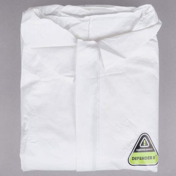 A folded white Cordova coverall in a clear plastic bag with a green label.