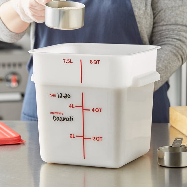 A person pouring rice into a white Vigor food storage container.