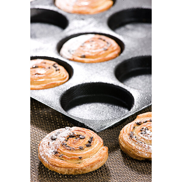 A Sasa Demarle Flexipan Air bread mold with 12 pastry rolls in it.