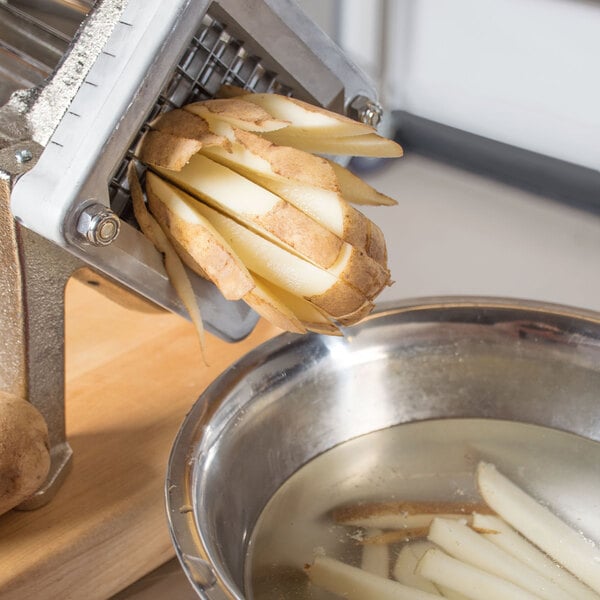 A person using a Vollrath French Fry Cutter to cut a potato.