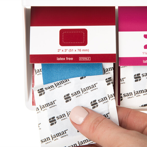 A person holding a box of San Jamar Mani-Kare large patch bandages.