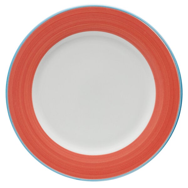 A close-up of a bright white porcelain plate with a coral and blue rim.