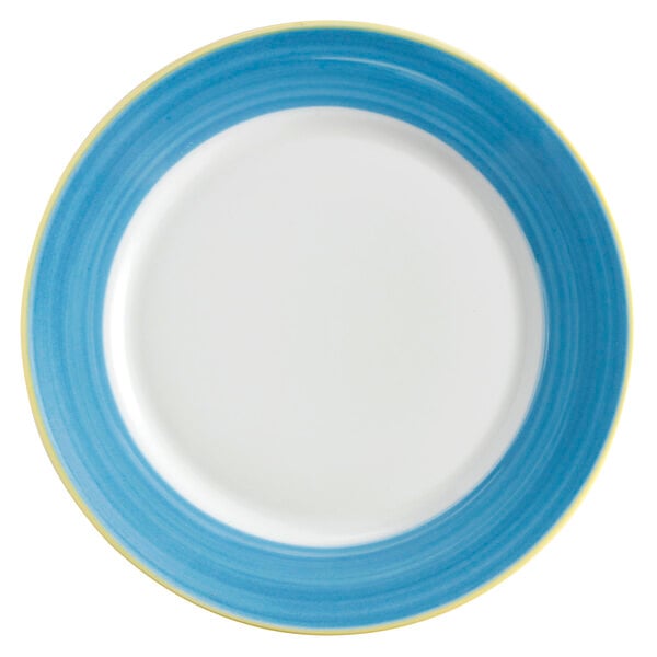 A close up of a white porcelain plate with a blue and yellow rim.