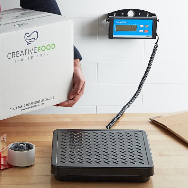 A person using an Avaweigh digital receiving scale to weigh a box.