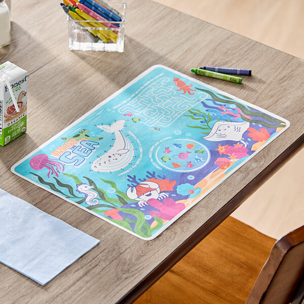A kids' under the sea themed interactive placemat with colorful sea creatures and activities, accompanied by a pack of crayons.