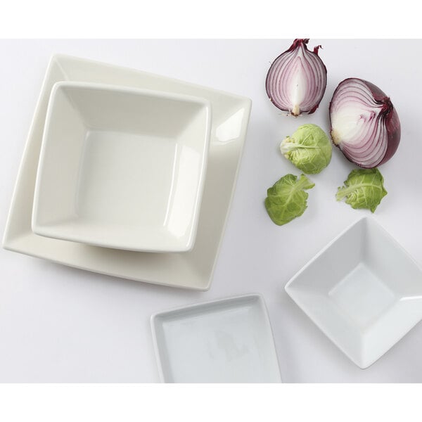 A Tuxton eggshell white square china plate with a red onion and a white square bowl.