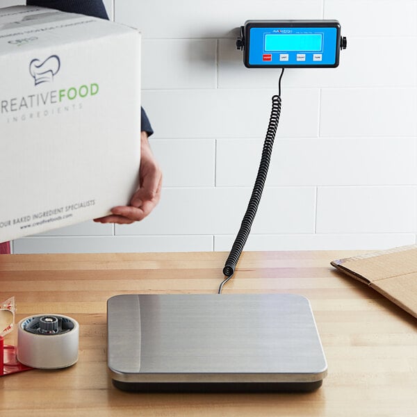 A person weighing a box on an Avaweigh low-profile digital receiving scale.