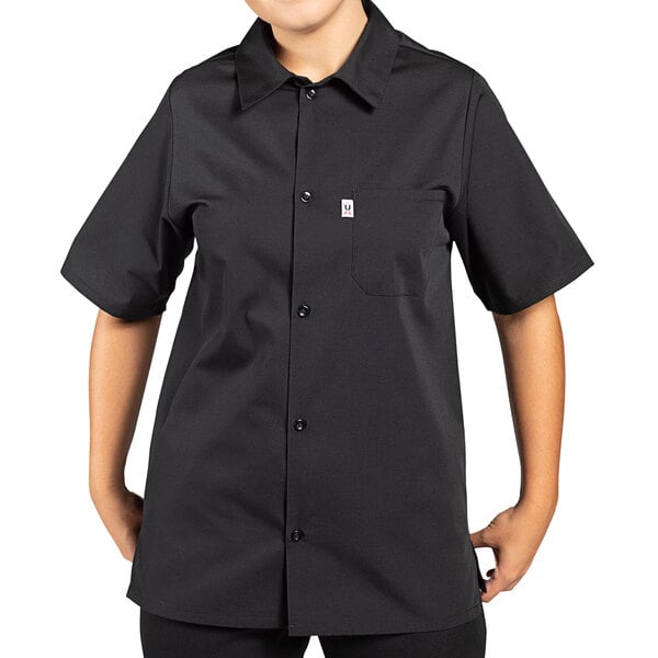 A person wearing a black Uncommon Chef short sleeve cook shirt.