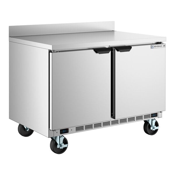 A stainless steel dual temperature worktop refrigerator and freezer with two doors and caster wheels.