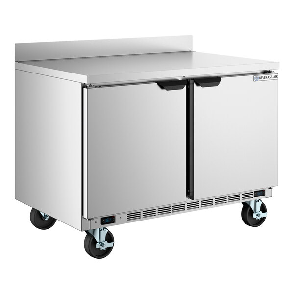 A stainless steel 48-inch dual temperature worktop refrigerator and freezer with two doors and caster wheels.