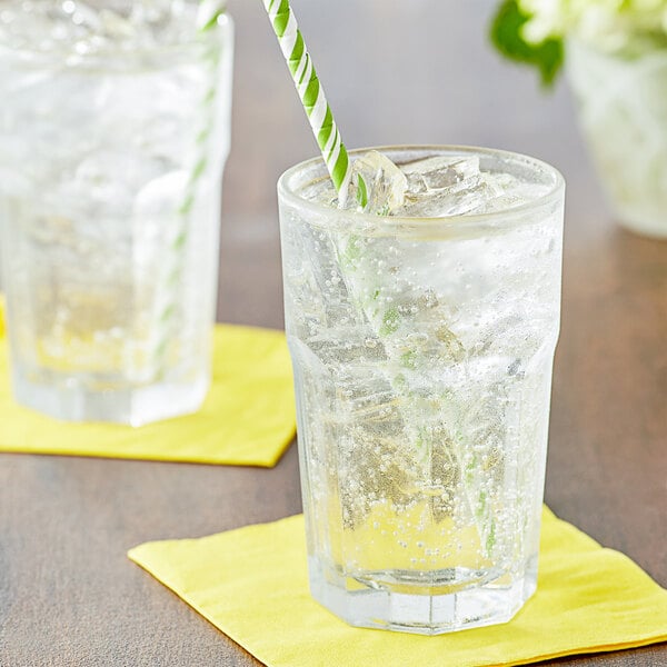 A glass of Boylan Lemon Lime soda with ice and a yellow and green striped straw.