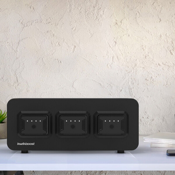 A black rectangular Luxor EdgePower charging station on a white table with four outlets.