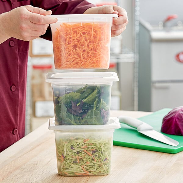 A person holding a San Jamar translucent plastic food pan with vegetables in it.