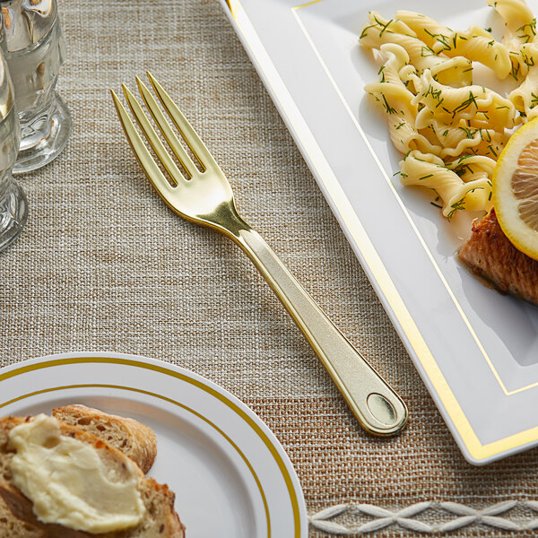 A plate of food with a Visions gold plastic fork and a piece of bread with butter.