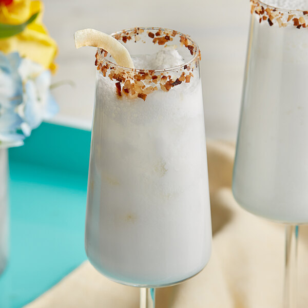 Two glasses of white liquid garnished with coconut.