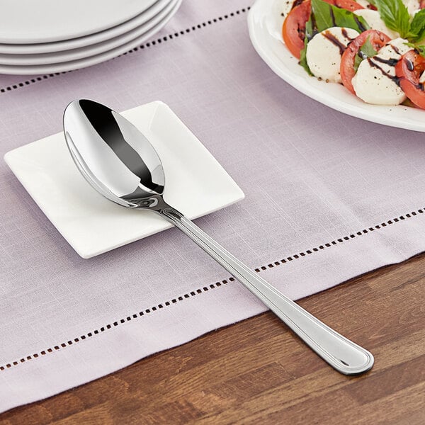 A stainless steel serving spoon on a plate.