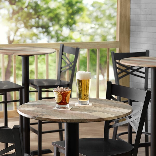 A Lancaster Table with glasses of beer and water on it.