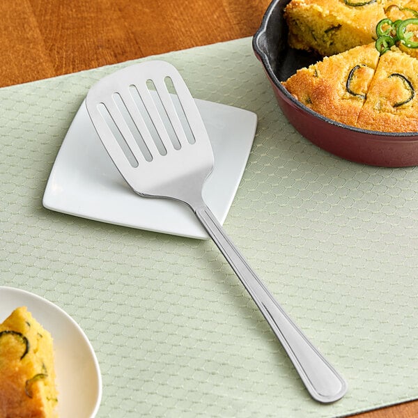 A GET slotted spatula on a plate of food.
