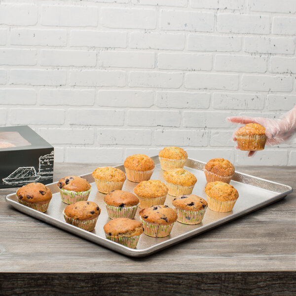 A Chicago Metallic bakery display tray of muffins on a counter.