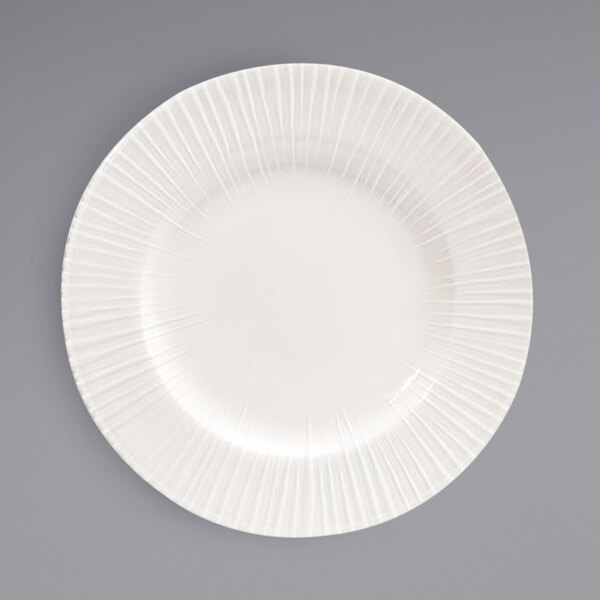 A Front of the House European white porcelain plate with a wavy circular pattern on the edge.