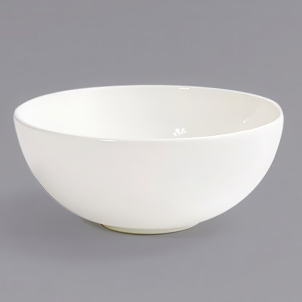 A Front of the House European White porcelain ramekin on a gray surface.