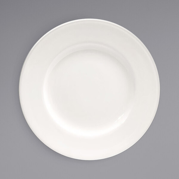 A white plate with a wide white rim on a gray background.