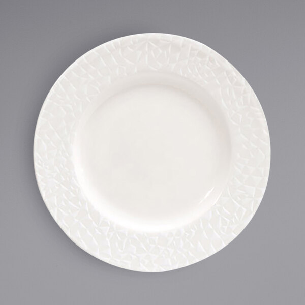 A Front of the House European white porcelain plate with a circular pattern on the rim.