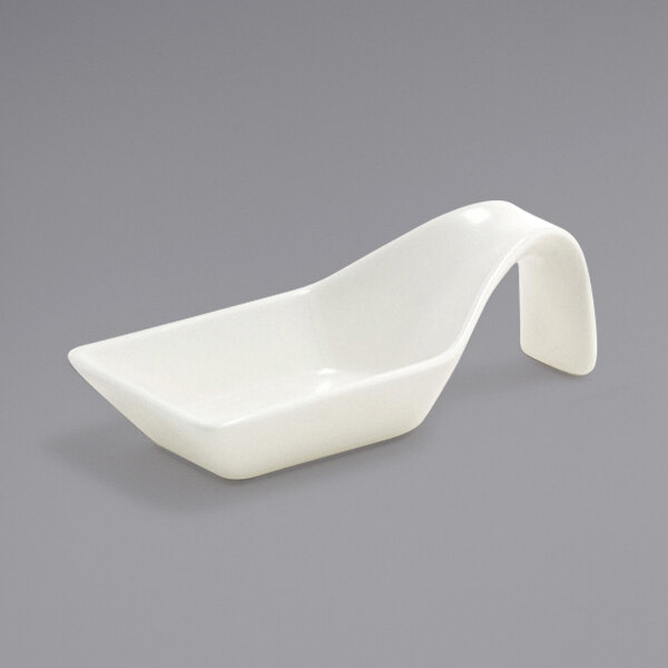 A Front of the House European white porcelain taster spoon with a curved handle.