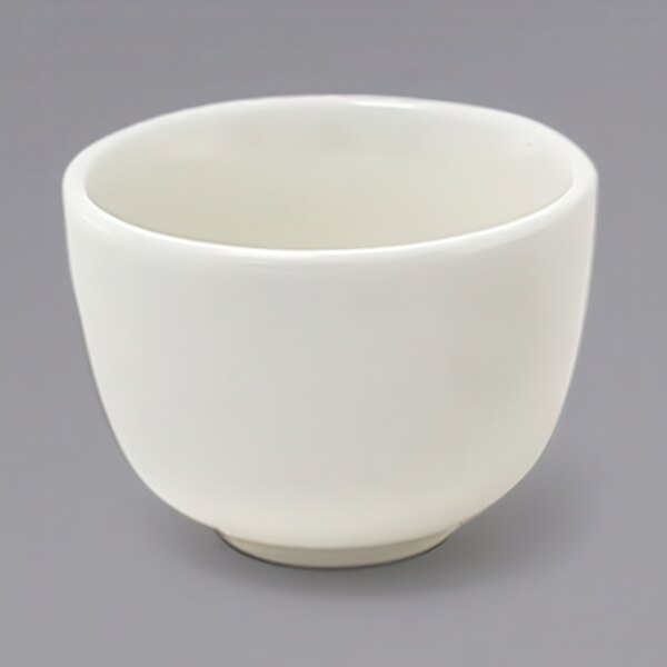 A Front of the House European white porcelain ramekin on a gray surface.
