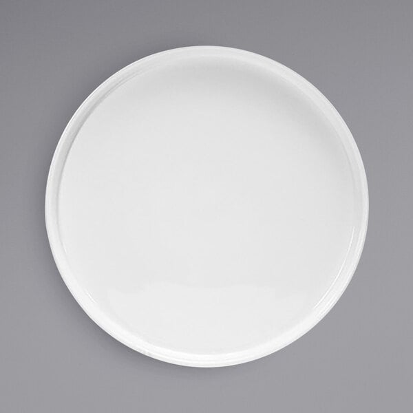 A white Front of the House Soho porcelain plate with a raised rim on a gray background.