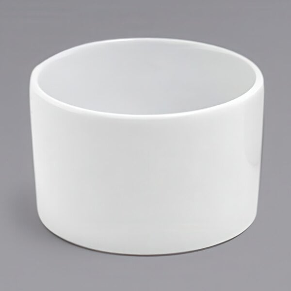 A close up of a white round Front of the House Soho ramekin on a gray surface.