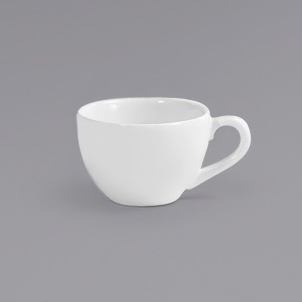 A Front of the House European white porcelain cup with a handle on a gray surface.