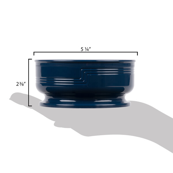 A navy blue Cambro entree bowl with measurements on a table.