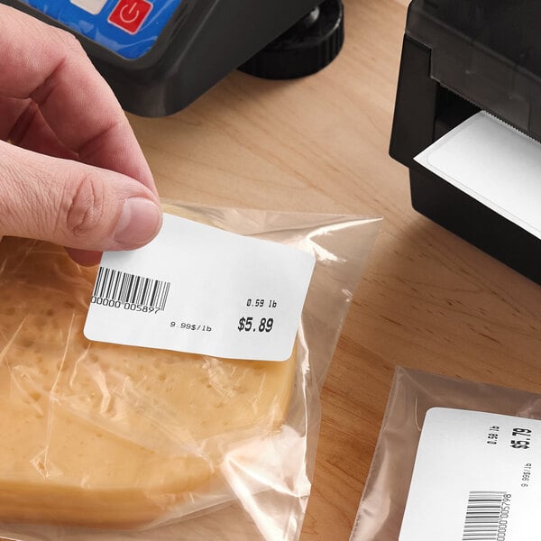 A roll of white blank permanent direct thermal labels being used for product packaging and pricing.